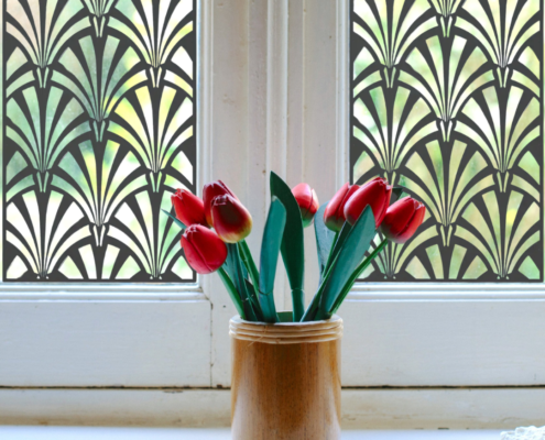 Fountain Decorative Metal Screen Used as a Privacy Window with a bunch of flowers in front of it.